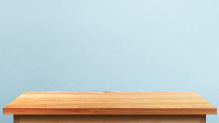 Empty wooden tabletop isolated on blue wall background. For your product placement or montage with...