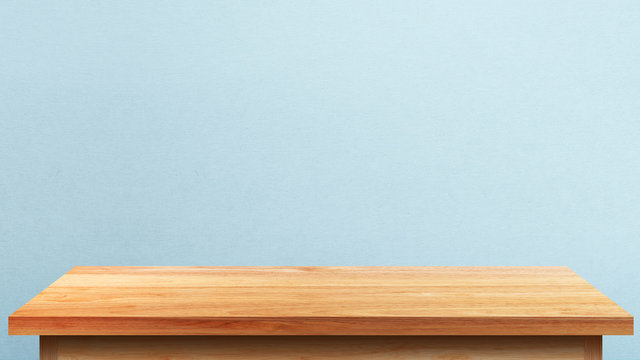 Empty wooden tabletop isolated on blue wall background. For your product placement or montage with focus to the table top in the foreground. Empty pine wooden shelf. shelves