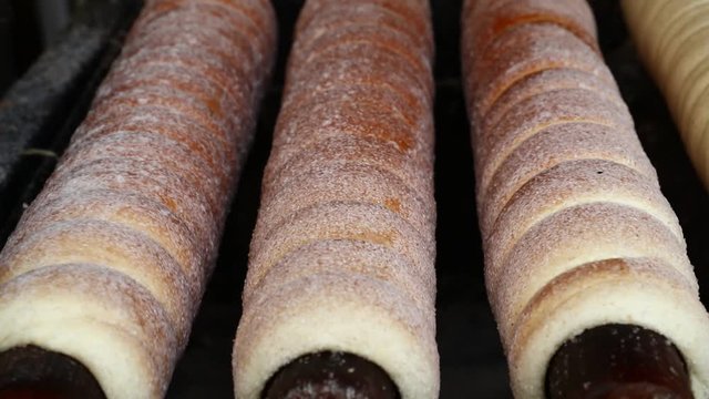 Close up chimney cake baking and rolling