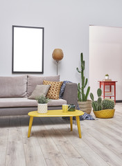 White wall room. Sofa near the cactus plant decoration. Stylish interior style. Empty frame useful