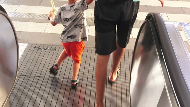 Father and son go down the escalator