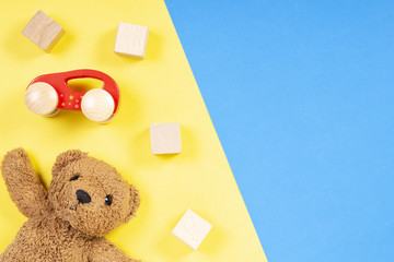 Colorful toys background with teddy bear, wooden cars and cubes