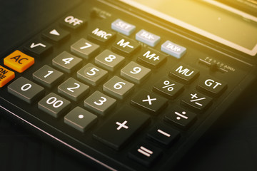 Fototapeta na wymiar Close up button calculator , calculator on table with flare light