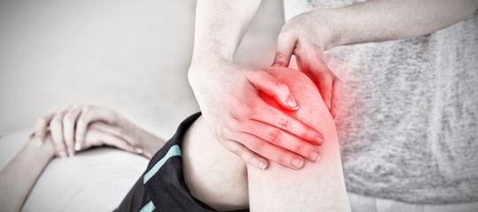 Composite image of masseuse massing the knee 