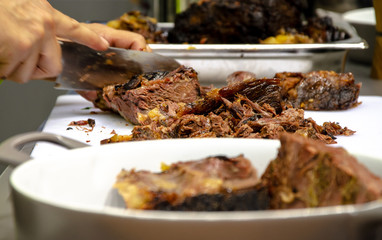 man slicing cooked meat