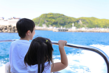 船尾から海を眺める兄妹