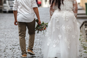 Fototapeta na wymiar Plus size Bride and Groom with the Bridal Bouquet