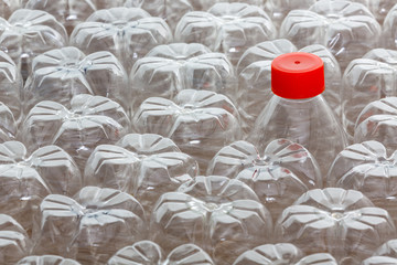 Plastic bottle with red cap amongst many without