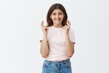 Keeping faith in good result. Intense worried attractive female student in trendy outfit holding...