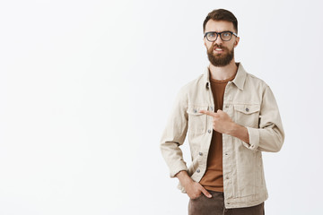 Studio shot of intense unsure and dissatisfied handsome caucasian guy with long brown beard and...