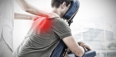 Composite image of physiotherapist giving shoulder massage to