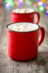 Christmas cocoa with marshmallow and Christmas lights background on wooden table


