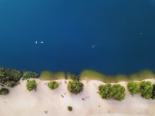arial veiw of sandy beach, green trees and blue sea (ocean, lake, river). drone shot