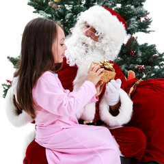 Young girl receiving gift from Santa sitting under the Christmas tree.