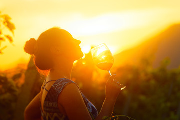 Portrait of woman in the vineyard having wine