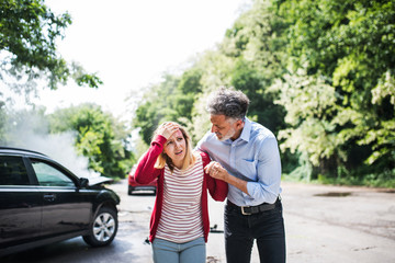 Fototapeta premium A mature man helping a young woman to walk after a car accident.