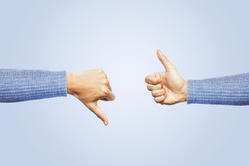 Hands showing different gesture thumb up and thumb down isolated on blue background. Clipping path...