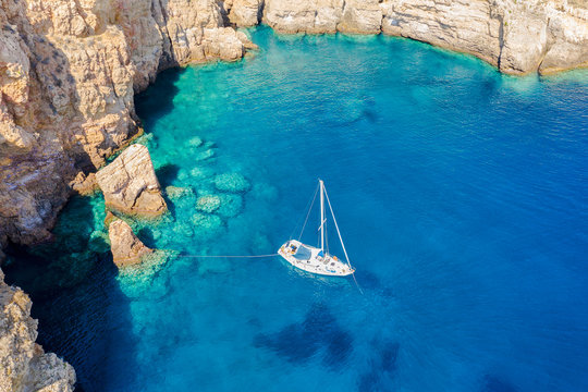 Luftaufnahme eines Segelbootes welches in einer einsamen Bucht im &Auml;g&auml;ischen Meer mit t&uuml;rkisem Wasser ankert
