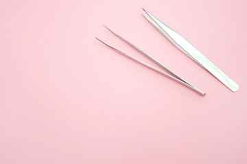 tools for Eyelash Extension Procedure. Two tweezers on pink background. copyspace mockup - Beauty and fashion concept - obrazy, fototapety, plakaty
