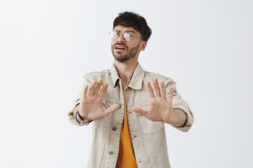 Intense dissatisfied and unimpressed handsome stylish man in glasses with trendy hairstyle bending...