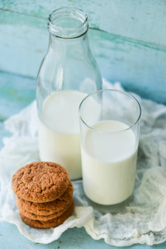 oat cookies and milk on blue wooden background