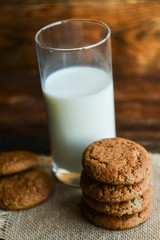 fresh oatmeal cookies and milk on wooden background with spikes of oats