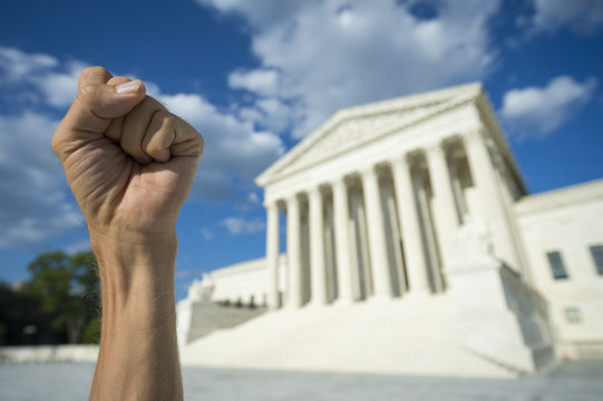 Hand clenched in fist symbol as sign of protest in front of US Supreme Court building in Washington DC