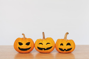 Pumpkins on wood table with white background. Halloween and decoration concept. Front view and copy space