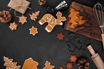 Christmas homemade gingerbread cookies, spices and cutting board on dark background with copy space for text top view. New year and christmas postcard