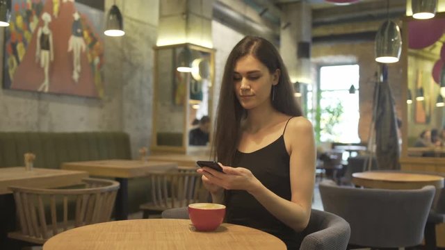 Woman Blogger with Smartphone in Restaurant