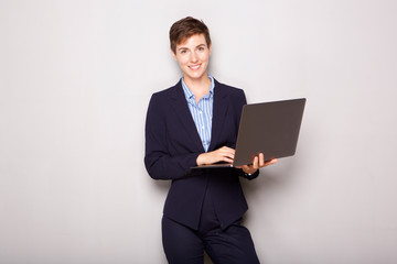 young business woman holding laptop computer by white background