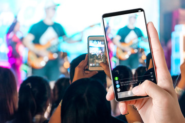People hands use smart phones record video concert music festival live streaming video on internet to social media comment chat to Friend