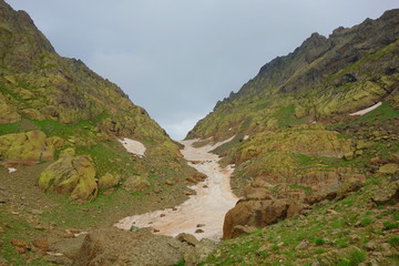 Hiking trail crossing a snowy Tobavarchkhili mountain pass in Caucasus Mountains in Georgia on a hike to Silver Lakes