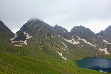 Naklejka na ściany i meble Tobavarchkhili lake with a snowy mountain pass in Caucasus Mountains on a hike to Silver Lakes in Georgia