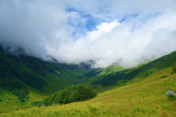 Fototapeta na wymiar Hiking trail to Silver lakes with clouds around the mountains going via Tobavarchkhili from Mukhuri to Khaishi in Caucasus mountains, Georgia
