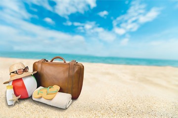 Straw hat, bag,  flip flops on a tropical beach