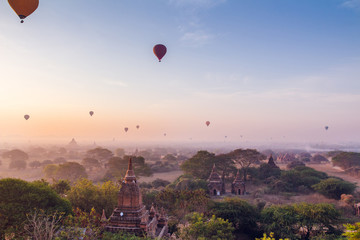  plain of Bagan Myanmar (Burma) whis fog is filled with the Golden light of the sun with the silhouettes of balloons