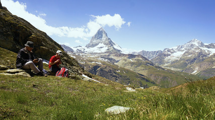 Fototapeta premium Father and Son Taking Break From Hiking in Swiss Mountains With Iconic Matterhorn Mountain in Background - Model Released