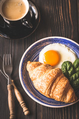 Fried egg with croissant and a cup of coffee