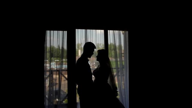 HD Frames From Wedding Day: Bride and Groom at the window of a hotel room in the evening