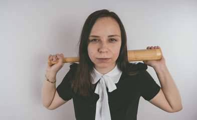 A girl in a black dress with a baseball bat in her hands. Concept: the bully at school