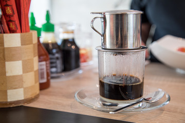 Traditioneller Vietnam Kaffee mit Tassenfilter und Kondensmilch im Café 