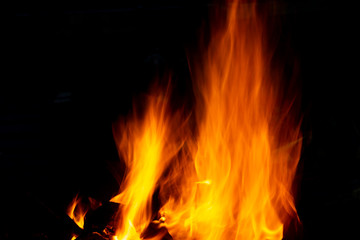 Flames of fire from burning coals in the grill late at night.