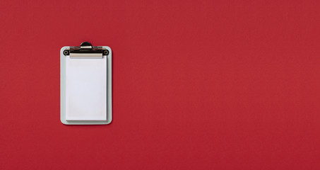 Clipboard on red horizontal background. Flat lay, top view trendy for banner
