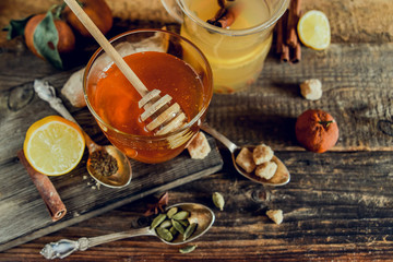 Fototapeta na wymiar Vitamin medicinal tea with lemon and honey, ginger and spices on wooden background . The concept of spring beriberi and colds.