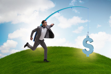 Businessman chasing money on fishing rod