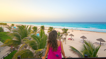 Young woman watching the beautiful Cancun beach at sunset, Mexico