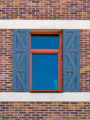 The texture of the window with shutters, against the wall of red brick. Close-up. Building background.