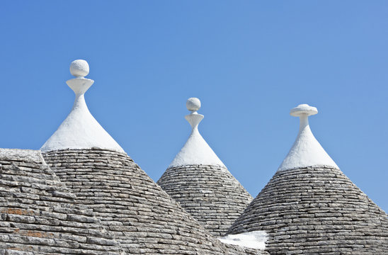 Close-up of conical limestone Trullo roofs against a blue sky, Alberobello, Puglia, Italy