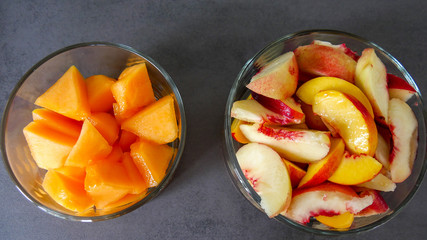 two glasses bowls with cut fruits top view